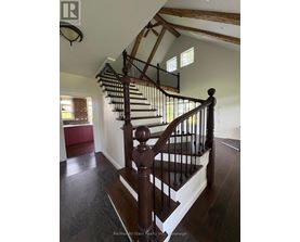 A wooden staircase with a metal railing.