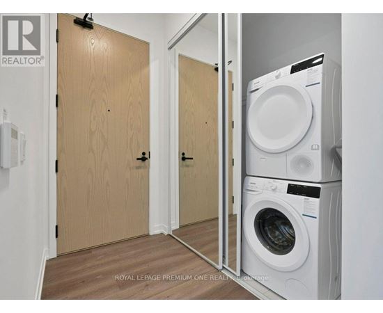 A laundry room with a washer and dryer stacked on top of each other.