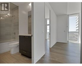 A bathroom with a toilet, sink, and a shower with a glass door.
