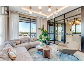 A living room with a large sectional sofa, a coffee table, and a view of the outdoors through large windows.