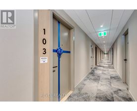 A hallway with a blue tape on the door and a sign that says "Occupier".
