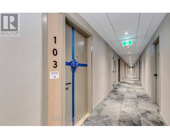 A hallway with a blue tape on the door and a sign that says "Occupier".