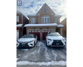 Two white Lexus cars are parked in front of a brick house.