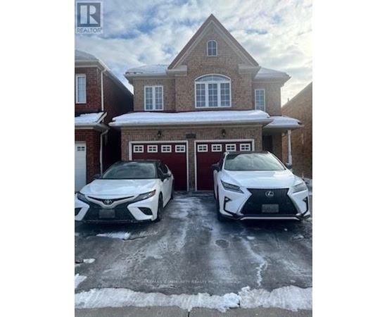 Two white Lexus cars are parked in front of a brick house.