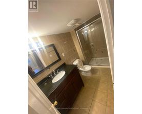 A bathroom with a sink, mirror, toilet and shower.