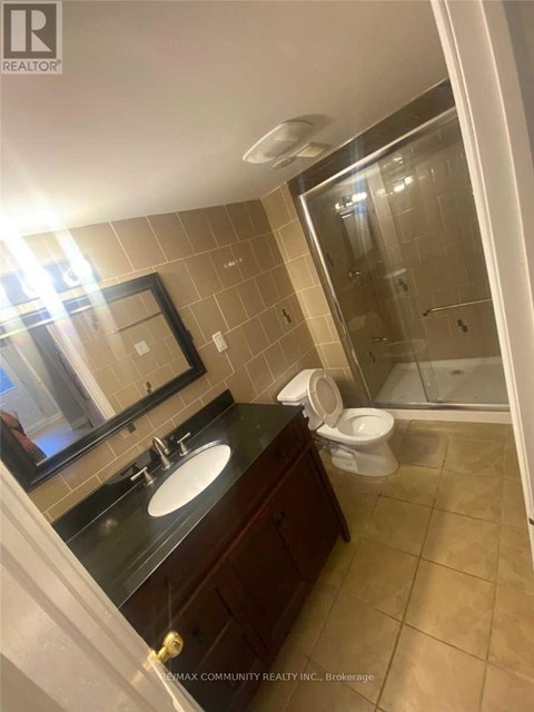 A bathroom with a sink, mirror, toilet and shower.