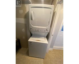 A white dryer is in a bathroom.