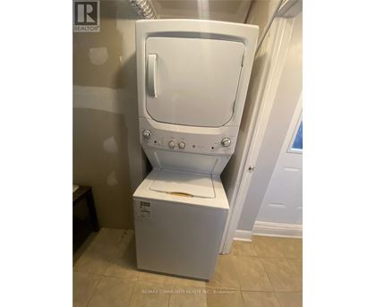 A white dryer is in a bathroom.