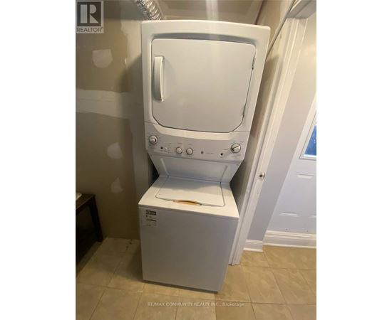 A white dryer is in a bathroom.