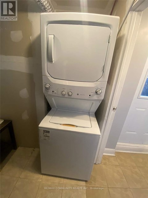 A white dryer is in a bathroom.