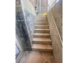 A staircase with a metal railing and concrete steps.