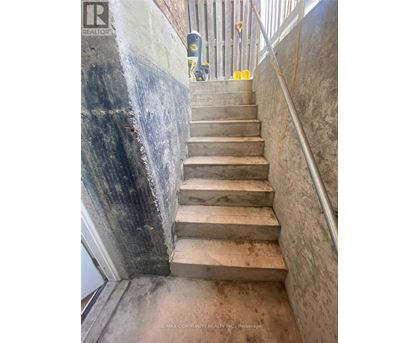 A staircase with a metal railing and concrete steps.