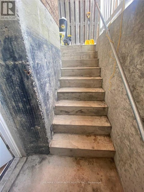 A staircase with a metal railing and concrete steps.
