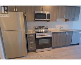 A modern kitchen with a refrigerator, oven, microwave, and sink.