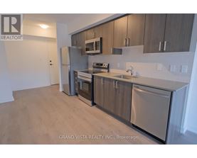 A kitchen with stainless steel appliances and wooden cabinets.