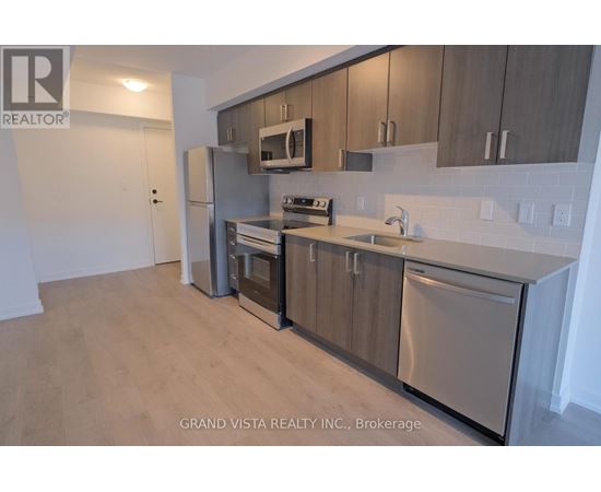 A kitchen with stainless steel appliances and wooden cabinets.
