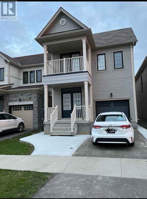 A white car is parked in front of a two-story house.