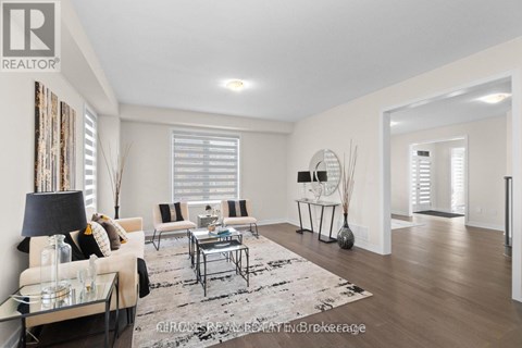 A well-lit living room with a glass coffee table and a sofa with a throw pillow.