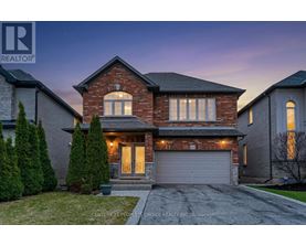 A house with a garage and a driveway in front of it.