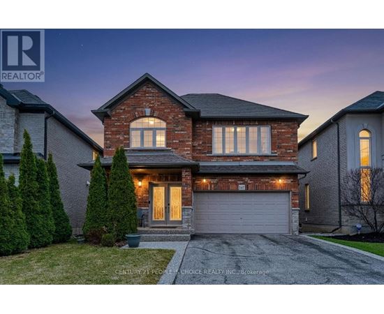 A house with a garage and a driveway in front of it.