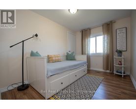 A bedroom with a white bed and a black floor lamp.