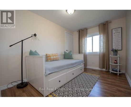 A bedroom with a white bed and a black floor lamp.
