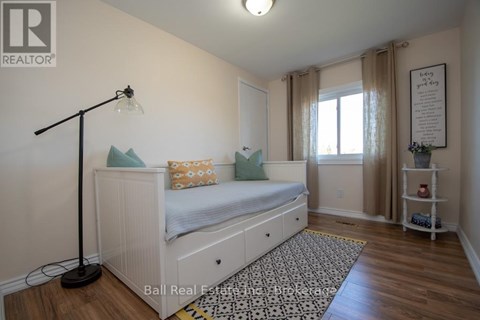 A bedroom with a white bed and a black floor lamp.