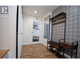 A hallway with a bench and a mirrored door.