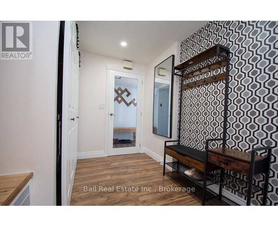 A hallway with a bench and a mirrored door.