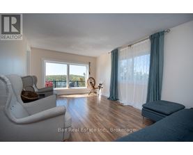 A living room with a white couch and a window with curtains.