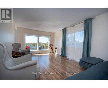 A living room with a white couch and a window with curtains.
