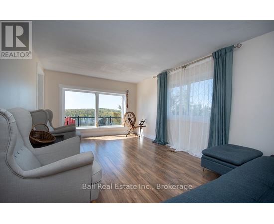A living room with a white couch and a window with curtains.