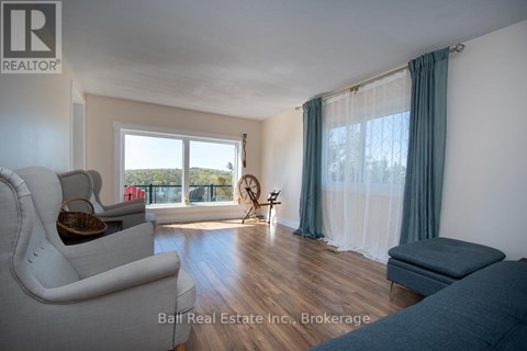 A living room with a white couch and a window with curtains.