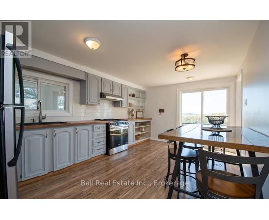 A kitchen with a table and chairs in front of a window.