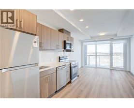 A well-lit kitchen with wooden cabinets and a refrigerator.