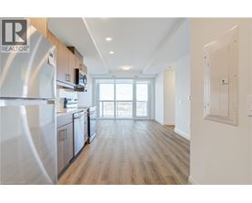 A modern kitchen with wooden floors and stainless steel appliances.
