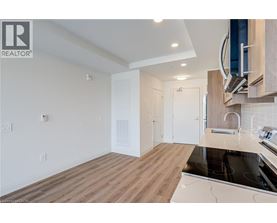 A modern kitchen with wooden floors and white walls.