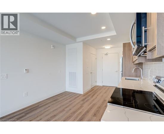 A modern kitchen with wooden floors and white walls.