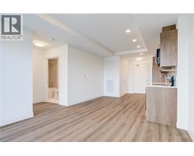 A spacious room with wooden flooring and white walls.