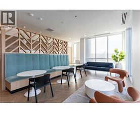 A modern waiting room with a blue sofa and wooden wall paneling.
