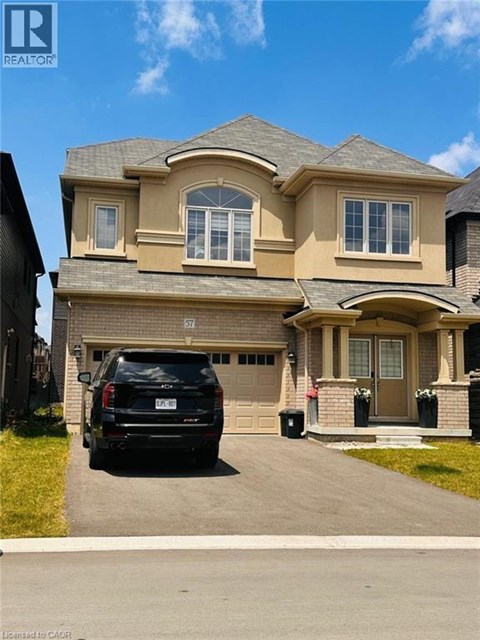 A house with a black SUV parked in front.