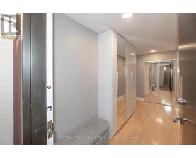 A hallway with a bench and a mirrored door.