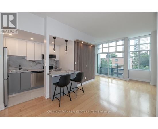 A modern kitchen with a dining area and a view of the outside.
