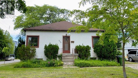 A white house with a brown roof and a red door.