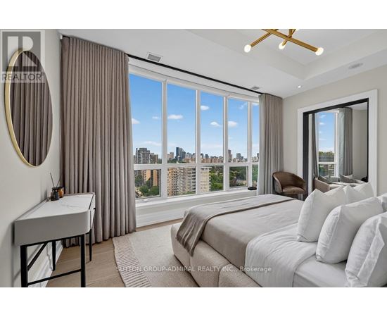 A bedroom with a large bed and a view of the city.