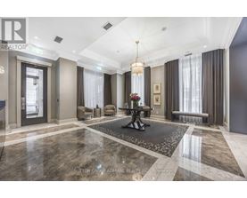 A well-lit, spacious lobby with a marble floor and a chandelier hanging from the ceiling.