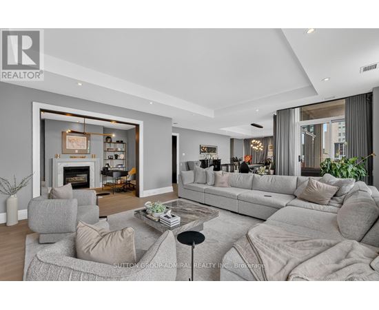 A modern living room with a grey sofa set and a fireplace.