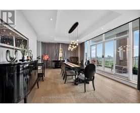 A modern dining room with a black cabinet and wooden chairs.