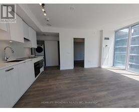 A spacious kitchen with white cabinets and a wooden floor.