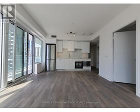 A spacious kitchen with white cabinets and a wooden floor.